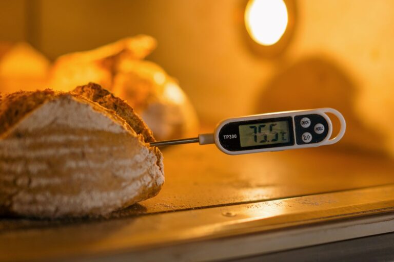 A digital thermometer measures the temperature of freshly baked bread, ensuring perfect baking results.