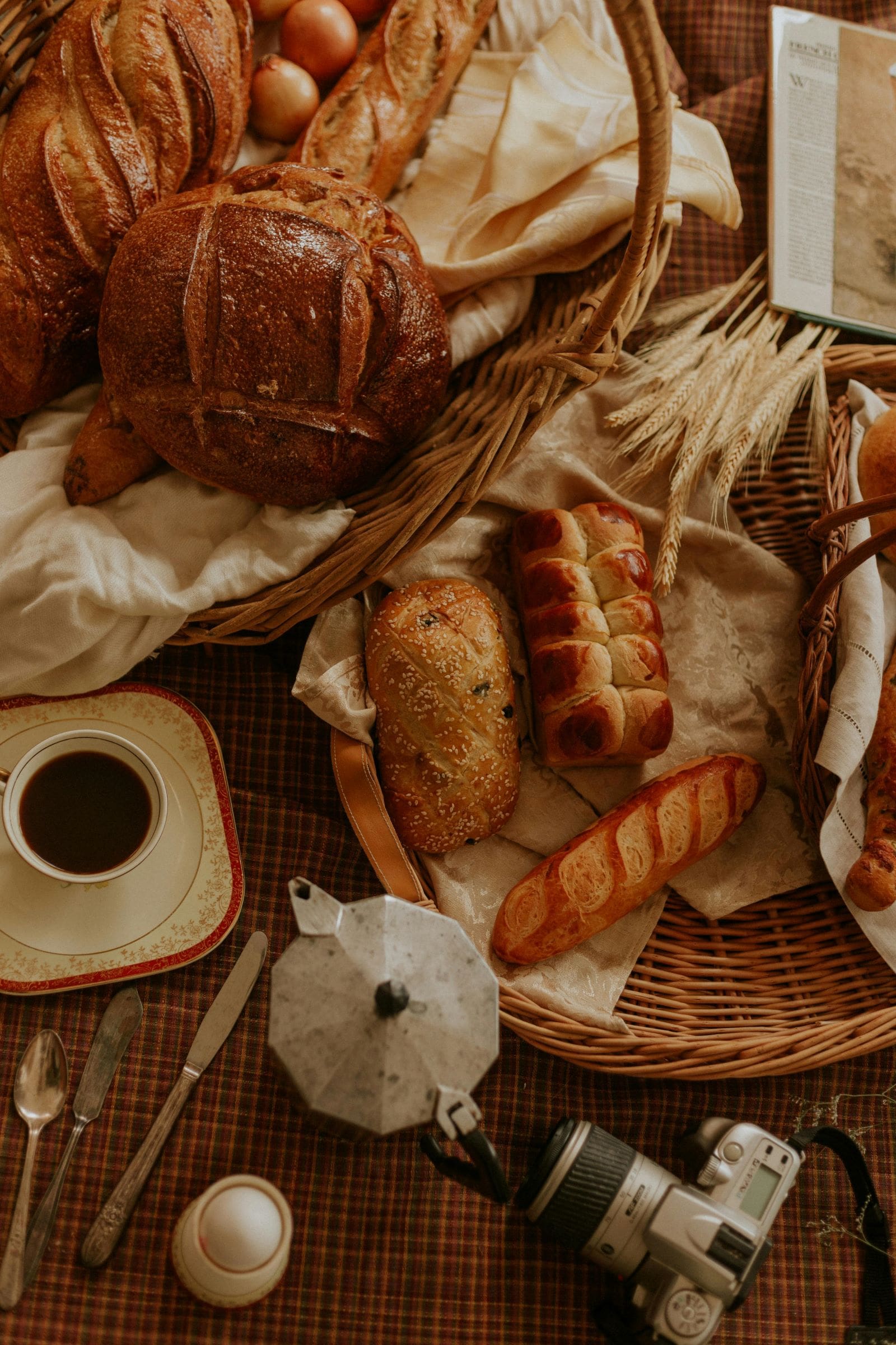 A cozy table set with a basket of fresh bread, steaming coffee, and delicious food, perfect for a baking session.