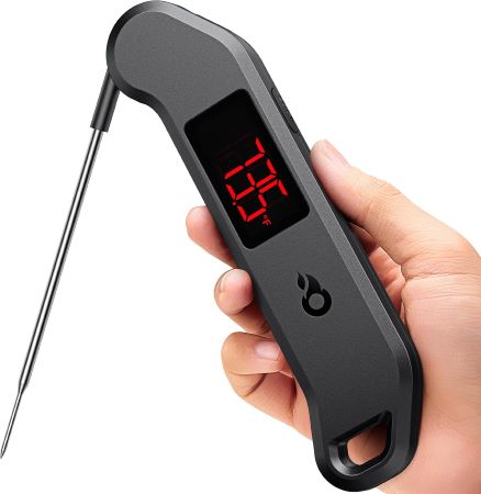 A person holds a digital thermometer in their hand, ready to check their temperature for health monitoring.
