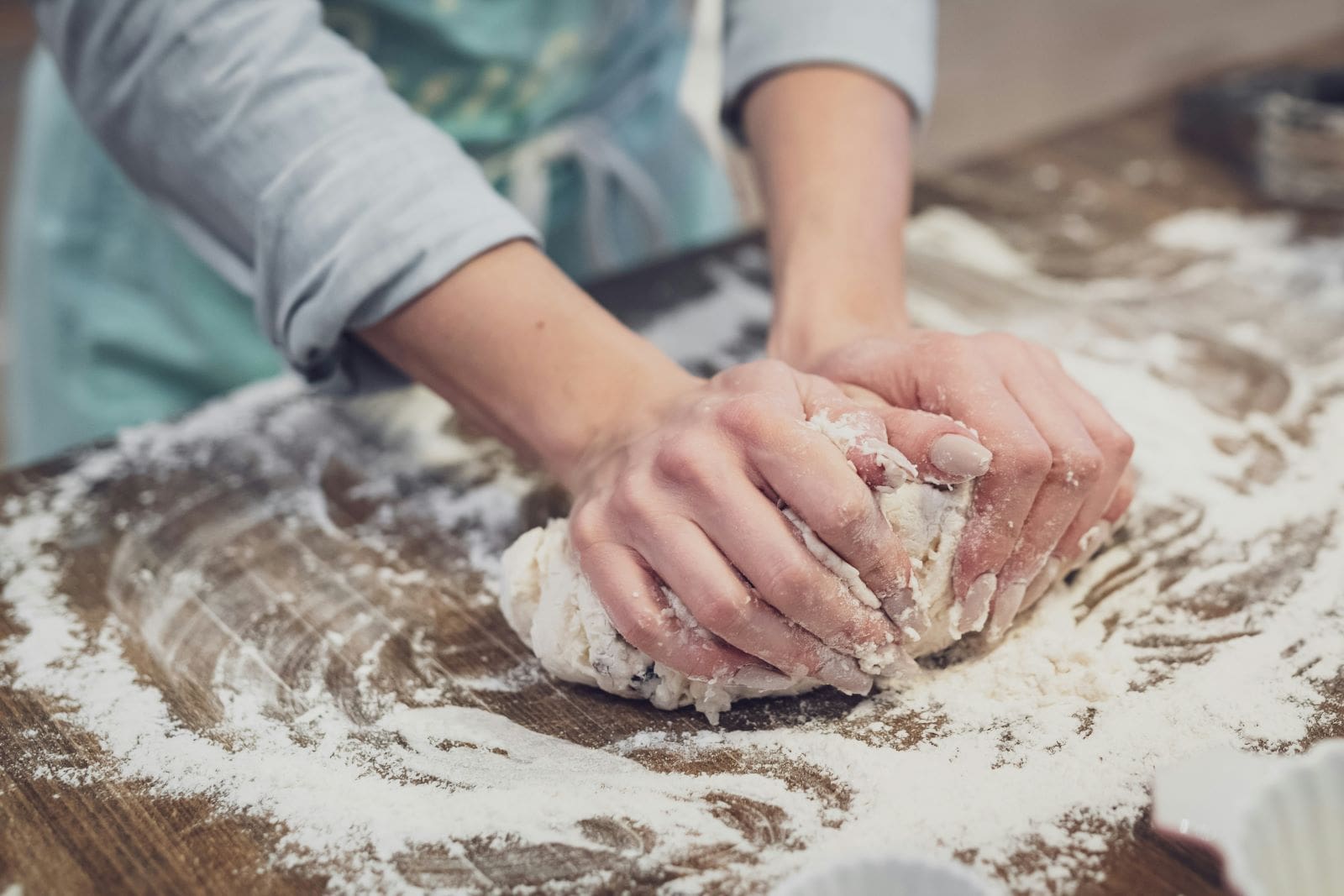 A person kneads dough on a table, using the best flour for making delicious homemade bread.