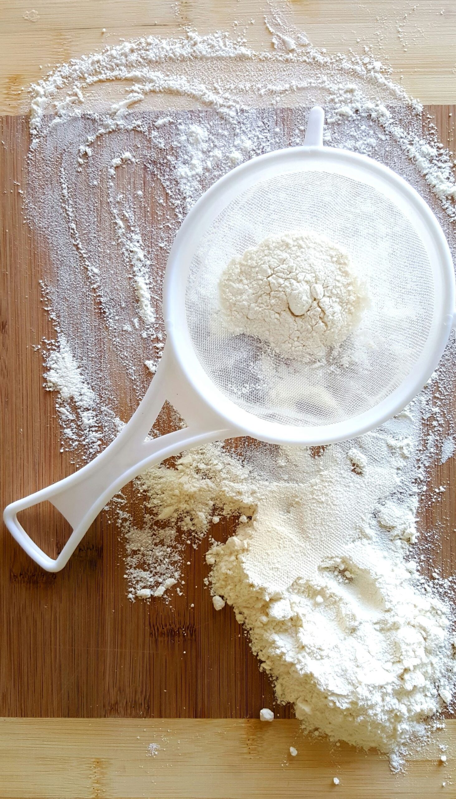 A white measuring cup next to a bowl of flour, perfect for baking delicious homemade bread.