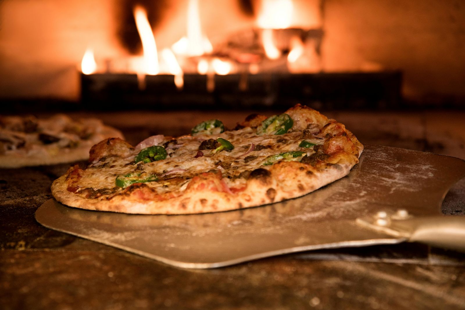 A freshly baked pizza in a wood-fired oven, showcasing the perfect crust and toppings, with a focus on dough kneading techniques.