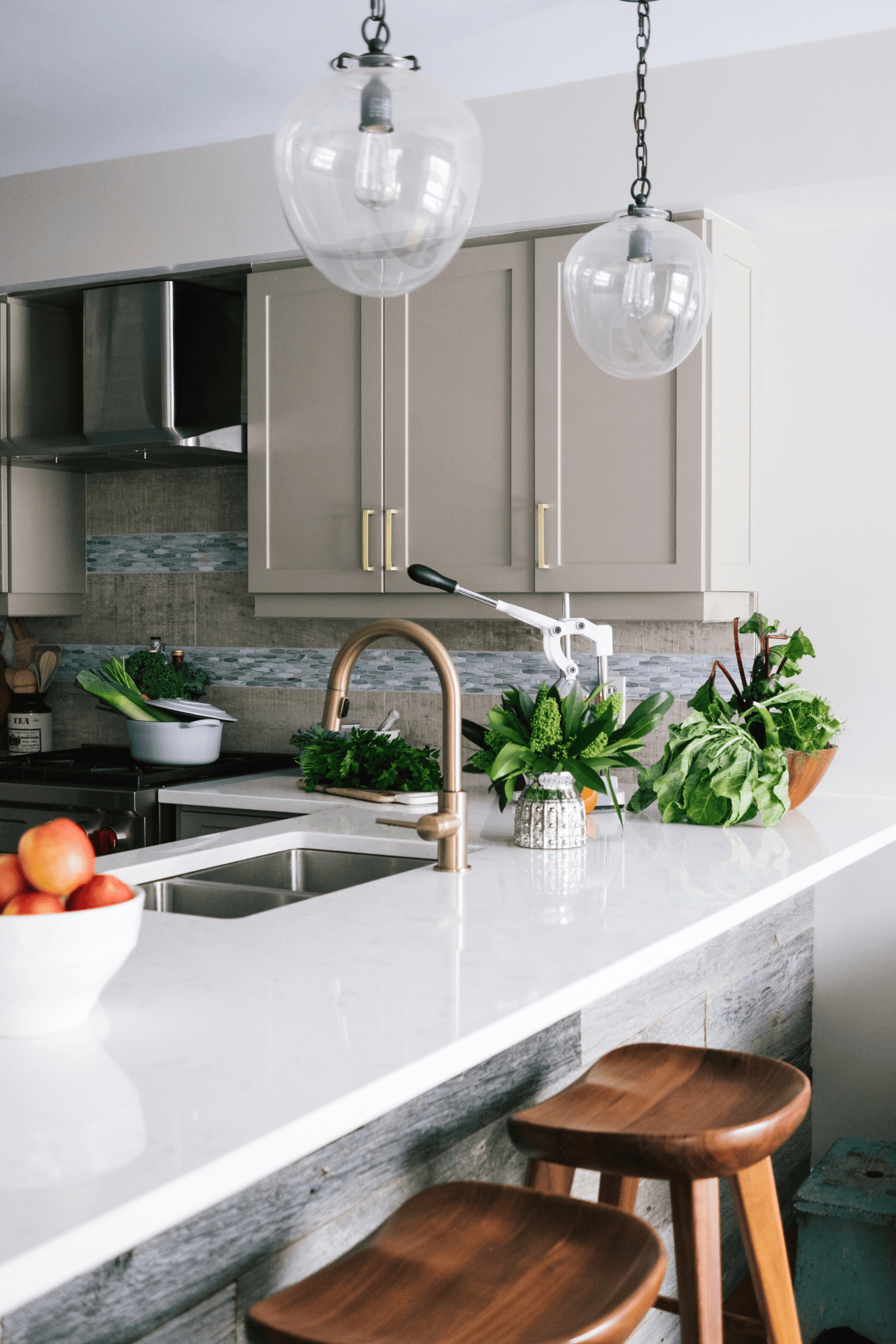 A modern kitchen featuring white cabinets and wooden stools, creating a bright and inviting cooking space